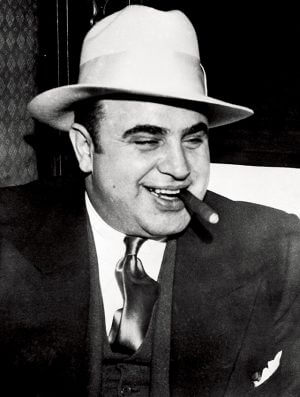 04 May 1932 --- Infamous gangster Al Capone smokes a cigar on the train carrying him to the federal penitentiary in Atlanta where he will start serving an eleven-year sentence. --- Image by © Bettmann/CORBIS