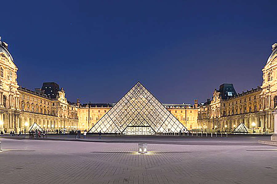 Napoleon courtyard of the Louvre museum at night time, with Ieoh Ming Pei's pyramid in the middle.